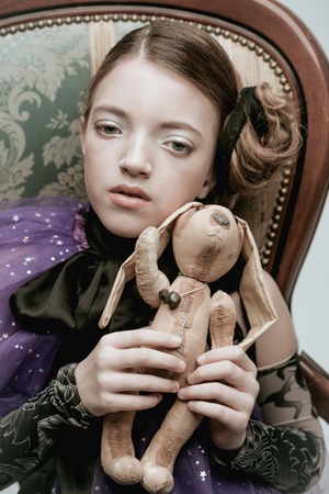 Beautiful girl child model in fashionable clothes holding a rabbit toyの写真素材