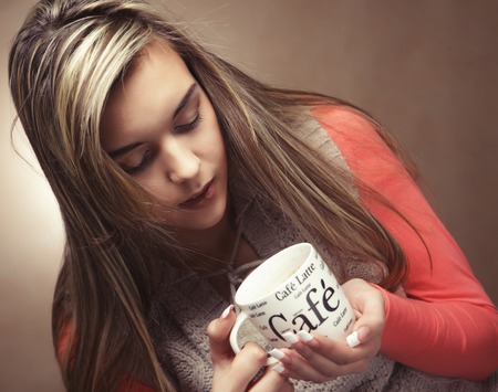 lifestyle, people and food concept: young pretty curly woman drinking coffeeの写真素材