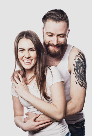 Happy couple embracing and looking camera on white backgroundの写真素材