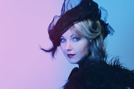 Elegant middle-aged woman in a black hat with a veil and a luxury dress.の写真素材