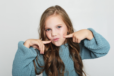Charming happy young girl. Portrait of pleased carefree adorable daughter with blond hair wearing casualの写真素材
