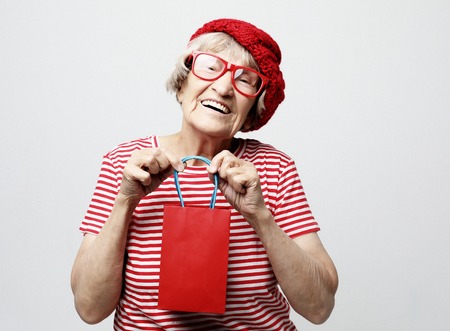 Lifestyle, holiday and people concept: elderly woman with gift bag.
