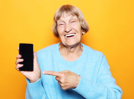 A picture of mature woman with new smartphone.の写真素材
