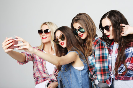 happy teenage girls with smartphone taking selfieの写真素材