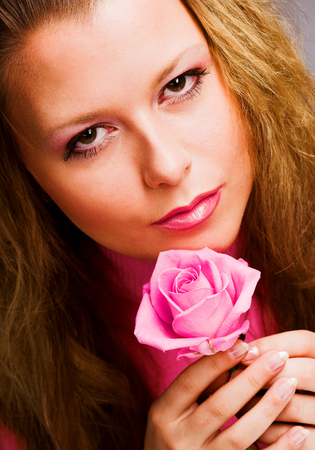 Pretty woman with pink roseの写真素材
