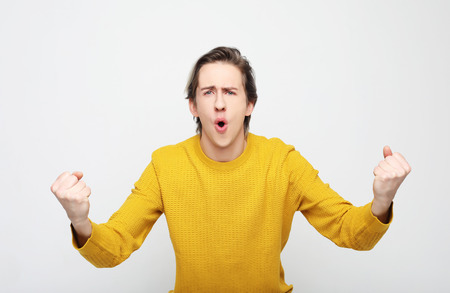 Young man celebrating victory over white