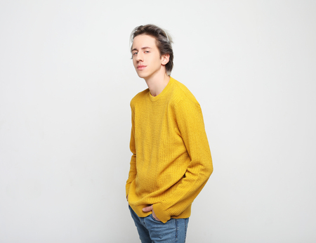 Young man with emotions on his face a greyの写真素材