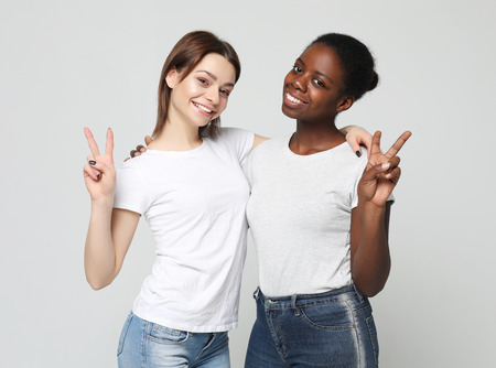 Multiethnic friendship concept. Cheerful European and African women.の写真素材