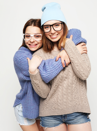 two pretty teen girlfriends smiling hugs and having funの写真素材