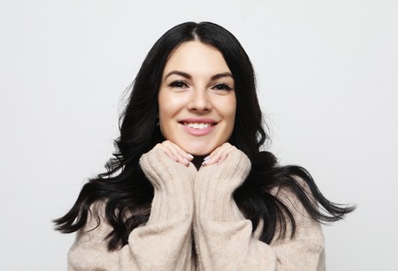 positive female with cheerful expression, dressed in casual clothes, over white  background. Beautiful woman indoor.の写真素材