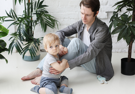 Happy father with his one year old son playing at home