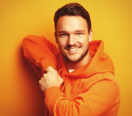 Portrait of a smart young man wearing casual standing against yellow backgroundの写真素材