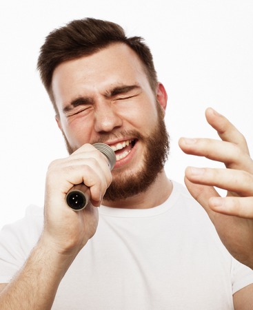 young bearded man in white shirt singing in microphoneの写真素材