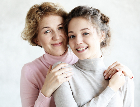 Lifestyle and people concept - Beautiful senior mom and her adult daughter are hugging, looking at...