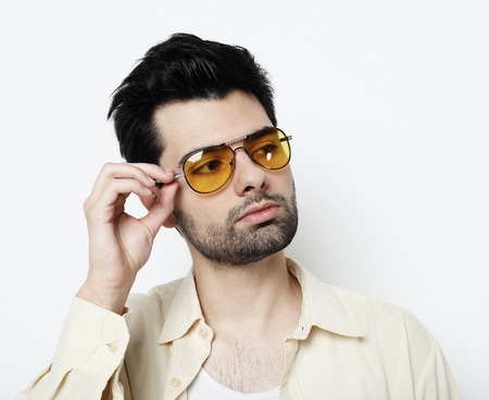 Elegant young handsome man in smart casual wear and sunglasses. Studio fashion portraitの写真素材