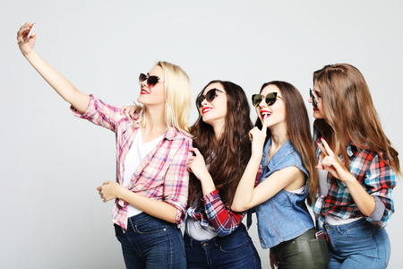 happy teenage girls with smartphone taking selfieの写真素材
