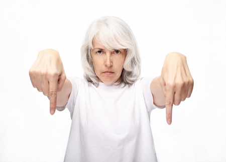 lifestyle and people concept: gray hairy elderly woman looking angry and showing thumb downの写真素材