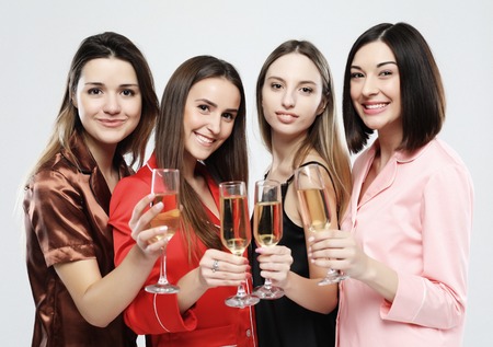 beautiful girls dressed in pajamas drink champagne and have funの写真素材