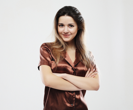 lifestyle, fashion, and people concept - beautiful girl dressed pajamas over white backgroundの写真素材