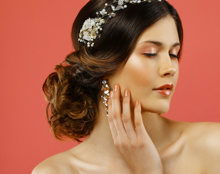 Wedding earrings on a female hand, she takes the earrings, wear earrings.の写真素材
