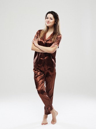 lifestyle, fashion, and people concept - beautiful girl dressed pajamas over white backgroundの写真素材