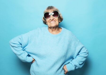 lifestyle and people concept: Happy grandmother wearing blue sweater smiling