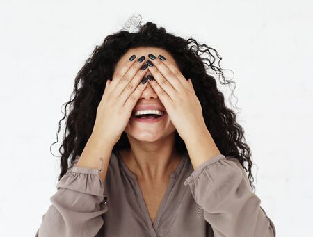 lifestyle, emotion and people concept - young woman covering her eyes with her hands over white backgroundの写真素材