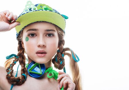 Bright fashionable teenager girl with creative make-up and braided pigtails, with a capの写真素材
