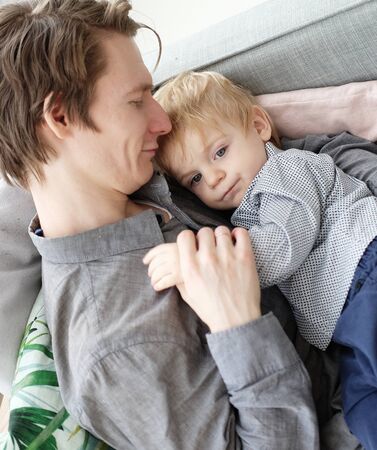 lifestyle, family and people concept - Happy young father with his one year old son playing at homeの写真素材
