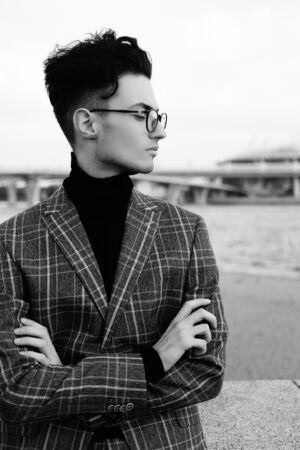 Elegant young handsome brunette man. Outdoors fashion portrait. Man with glasses.Black and white picture.の写真素材