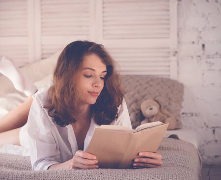 lifestyle and people concept:Young woman lying in bed while read