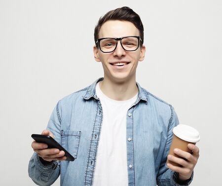 Portrait of happy man talking on phone and drinking coffee