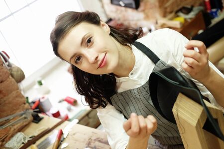 Young woman works in a bag making studio, cuts out detailsの写真素材