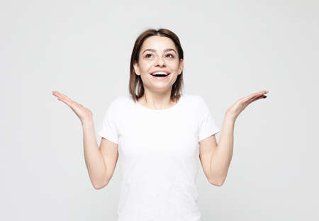 Surprised young woman looking sideways in excitement.の写真素材