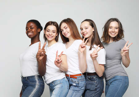 Cheerful European, Asian and African womens in good mood showing OK and victory.の写真素材