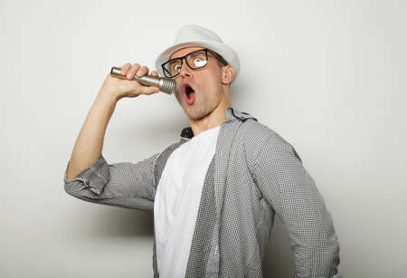 Time for karaoke. Young man singing with microphone
