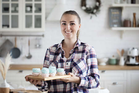 Young baker woman holding pastries. Happy, smiling and cheerful.の写真素材