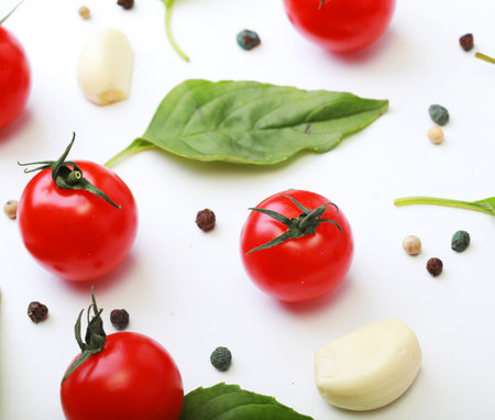 Tomato cherry, basil, spices, pepper. Fresh organic tomatoes, isolated on white.の写真素材