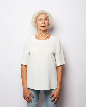 Mature woman with white hair in studio and white backgroundの写真素材
