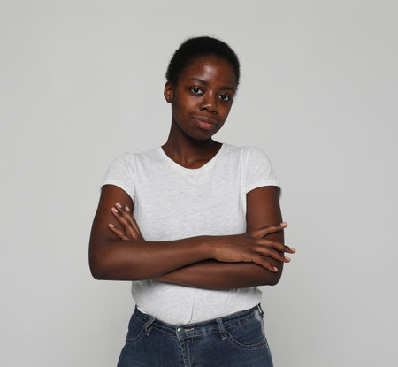 Portrait of beautiful happy black woman standing with arms crossedの写真素材