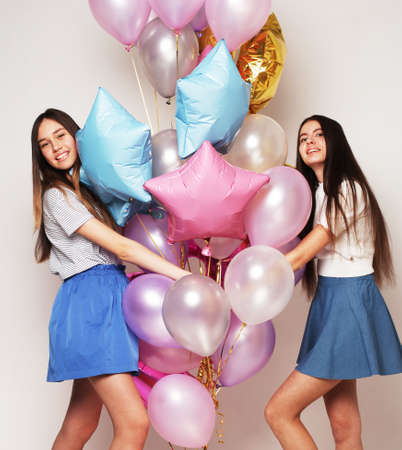 lifestyle and people concept: two girls friends with colorfoul air balloonsの写真素材