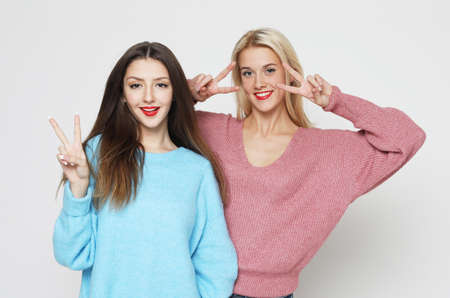 Photo of emotional two women friends standing isolated over white background.の写真素材