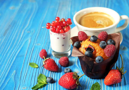 Good morning, Breakfast. Cupcake with berries, a cup of coffee and yogurt with red currants. Close up.の写真素材