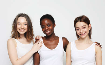 lifestyle, friendship and people concept - group of three girls friends of different nationalitiesの写真素材