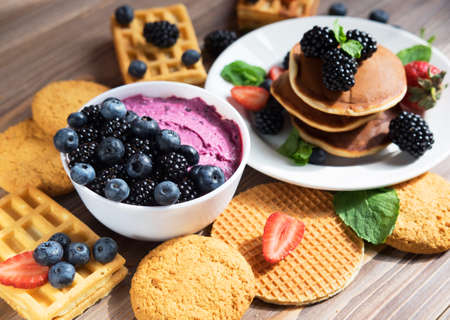 Pancakes with fresh berries. Breakfast setting. Cottage cheese, waffles and coffee. Close up.の写真素材