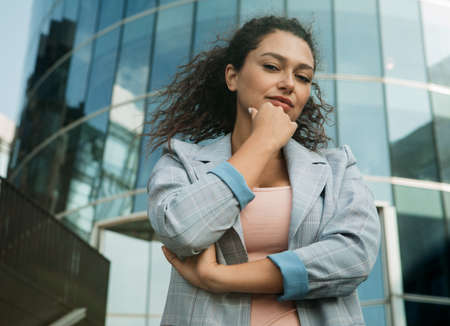 Young african american woman near modern business center, summer day, business concept