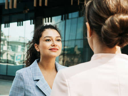 Two diverse businesswomen. Excited afro female sharing ideas or startup business plan with blond woman.の写真素材