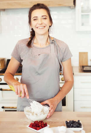 Woman Hand Mixed Batter on Clear Bowl with Baloon Whisk Step by Step Baking Preparation in the Kitchenの写真素材