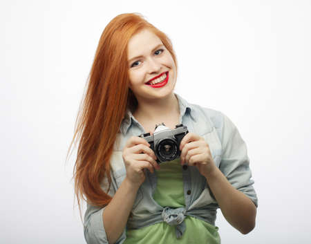 Girl on a white background. Holding a vintage camera in his hand.の写真素材