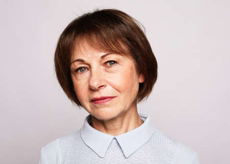 Cheerful elderly woman standign on white backgroundの写真素材